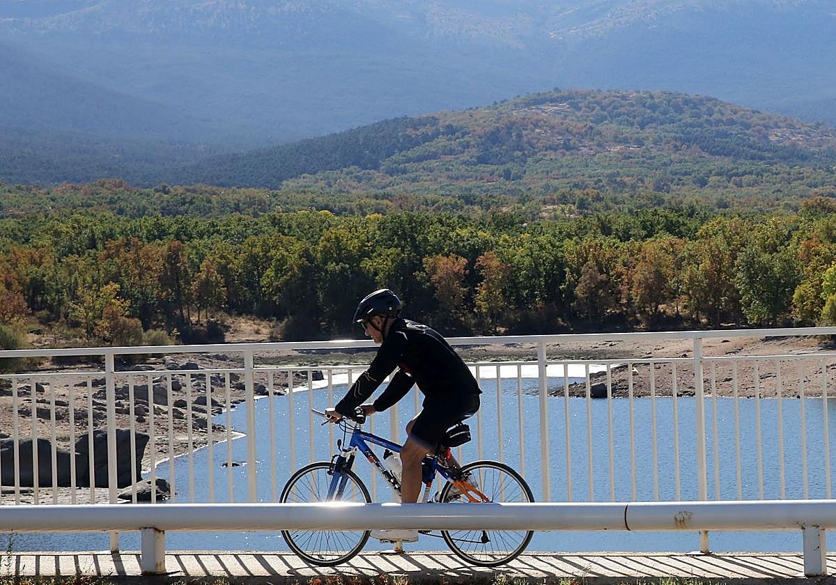 Un ciclista circula por la pasarela sobre la presa del Pontón Alto, en Segovia.