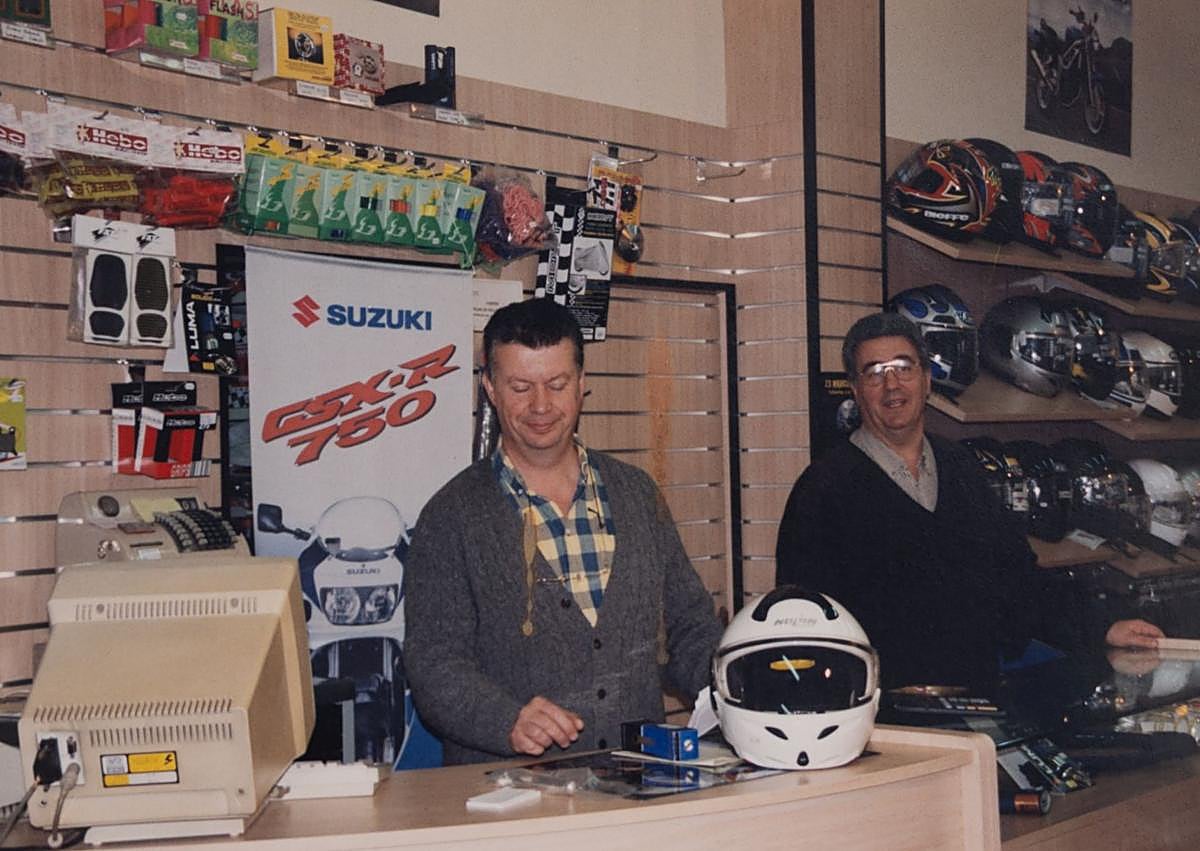 Imagen secundaria 1 - Arriba, la leyenda Ángel Nieto con José Mari Fernández. Enrique y Francisco Javier, detrás del mostrador y Enrique con una Suzuki, en imágenes antiguas.