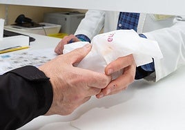 Una persona retira varios medicamentos de una farmacia, en una imagen de archivo.