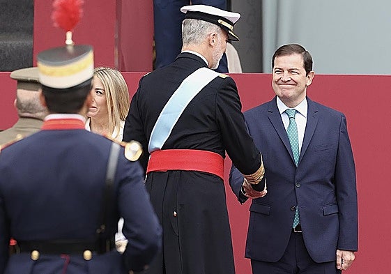 Fernández Mañueco saluda al Rey Felipe durante el acto de homenaje a la bandera nacional y al desfile militar con ocasión del día de la Fiesta Nacional.
