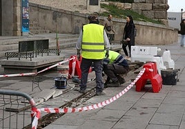 Operarios de una brigada de reparación rápida realizan una reparación en la plaza del Azoguejo de Segovia.