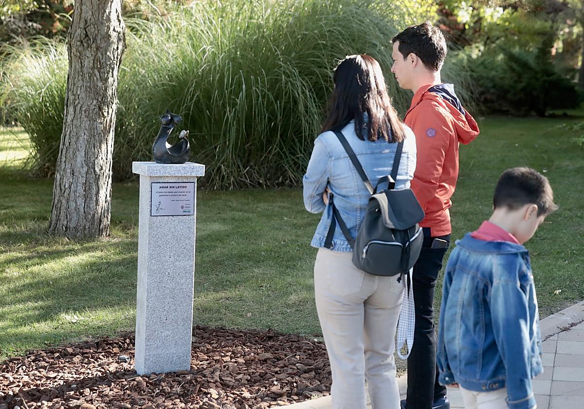 Una familia junto al monolito en recuerdo de los bebés fallecidos, en el cementerio de Las Contiendas.