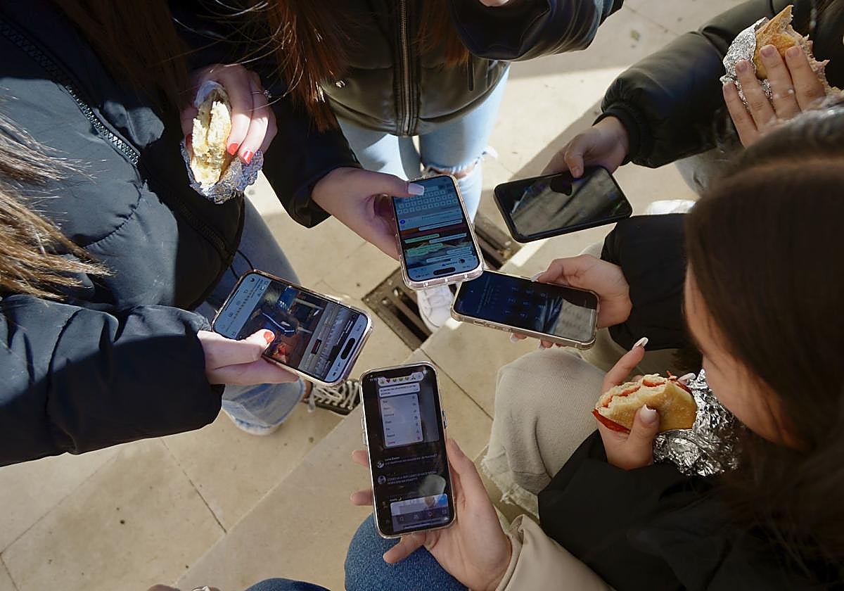 Alumnos haciendo uso del movil en la hora de recreo.
