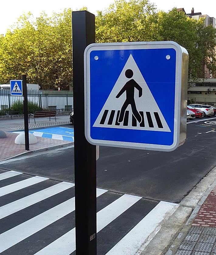 Imagen secundaria 2 - Arriba, la vieja señal de 'zona escolar' que se mantiene en la entrada a Manuel Silvela desde Hernando de Acuña. Debajo, a la izquierda, la nueva marca vial, situada a continuación, con la nueva limitación a 20 kilómetros por hora. A la derecha, la señal, con las dos luces led, del paso inteligentes instalado ante el colegio Tierno Galván.