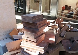 Restos de madera entre las cajas de cartón.