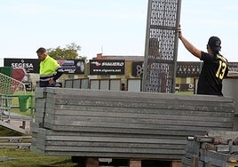 Operarios trabajan en la instalación de las gradas supletorias en el estadio municipal de La Albuera para el partido contra el Ávila.