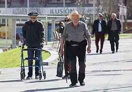 Varios jubilados paseando por una calle.