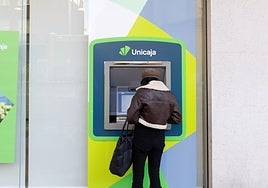 Una mujer saca dinero de un cajero, en una imagen de archivo.