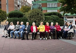 Eutiquio, Chus, Alfredo, Román, Alejandro, María Teresa, Magdalena, María Jesús, Angelines, Asunción, Violeta y Victoria, sentados en el banco de piedra bajo 'La unión del mundo'.