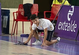 Uno de los jóvenes canteranos limpiando la gotera durante el partido.