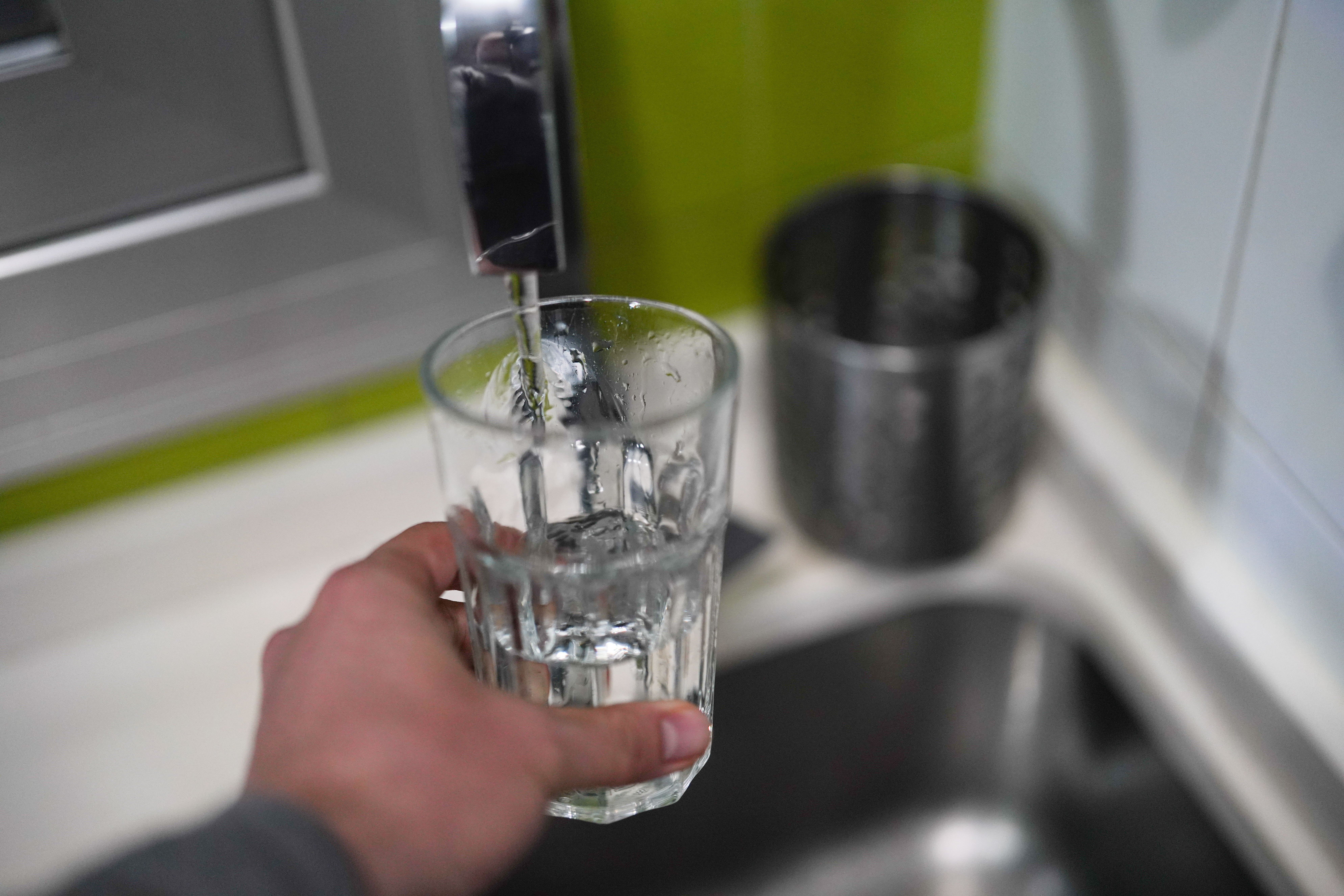 Una persona llena un vaso de agua.