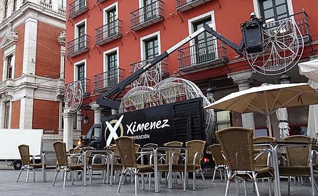 Un operario coloca un adorno en un balcón de la Plaza Mayor, este miércoles por la mañana.