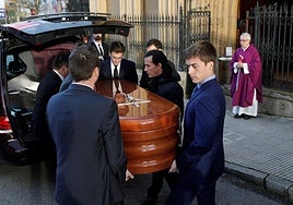 Familiares y empleados de una funeraria trasladan un féretro a una iglesia.