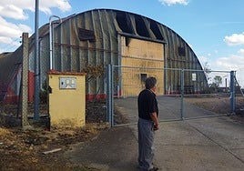 El alcalde de Cubo de Benavente, Emiliano Bresme, delante de la nave que estuvo cinco días ardiendo.