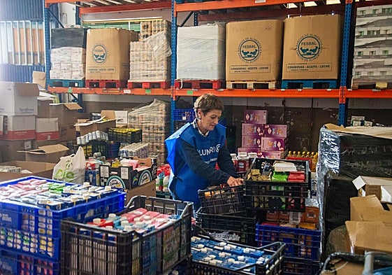 La secretaria del Banco de Alimentos, Rosa Ortega, organiza la comida para los usuarios en la sede de la entidad.