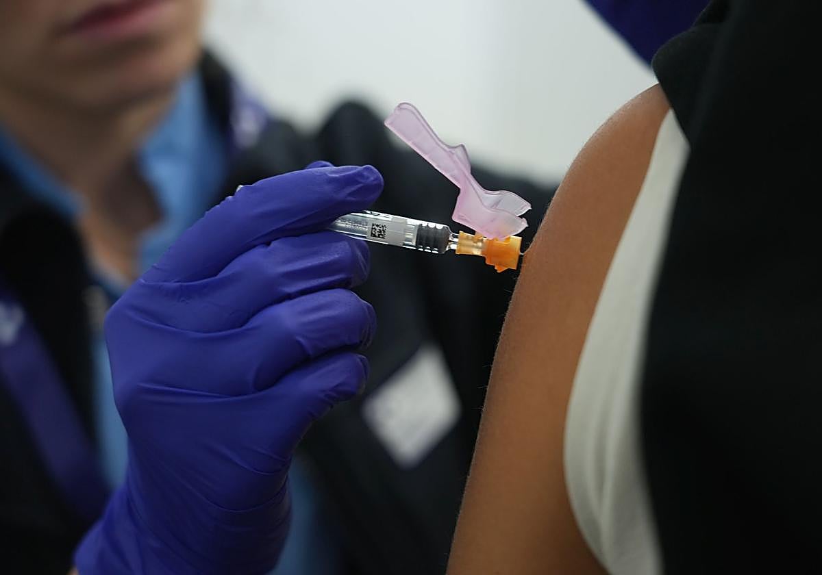 Una sanitaria inyecta una dosis de la vacuna frente a la gripe.