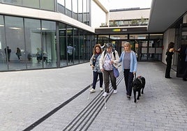 Tres mujeres ciegas, una de ellas con su perro guía, salen de la nueva sede la ONCE en la calle de la India.