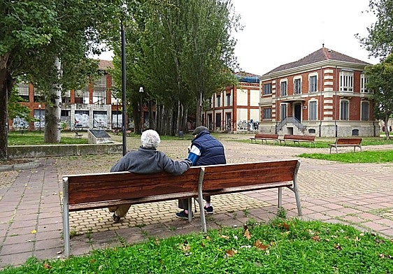 Dos hombres sentados en la entrada de la futura plaza de Antonio Piedra, en el parque de Las Norias. A la derecha, la sede de la Fundación Jorge Guillén. Detrás, el segundo chalé que ocupará el Centro Francisco Pino. Detrás, la vieja azucarera Santa Victoria.