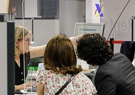 Una funcionaria de Hacienda atiende a dos contribuyentes.