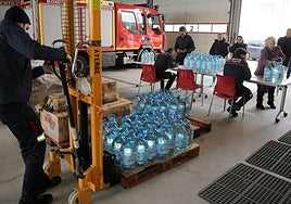 Los bomberos reparten agua durante un episodio de contaminación del agua.