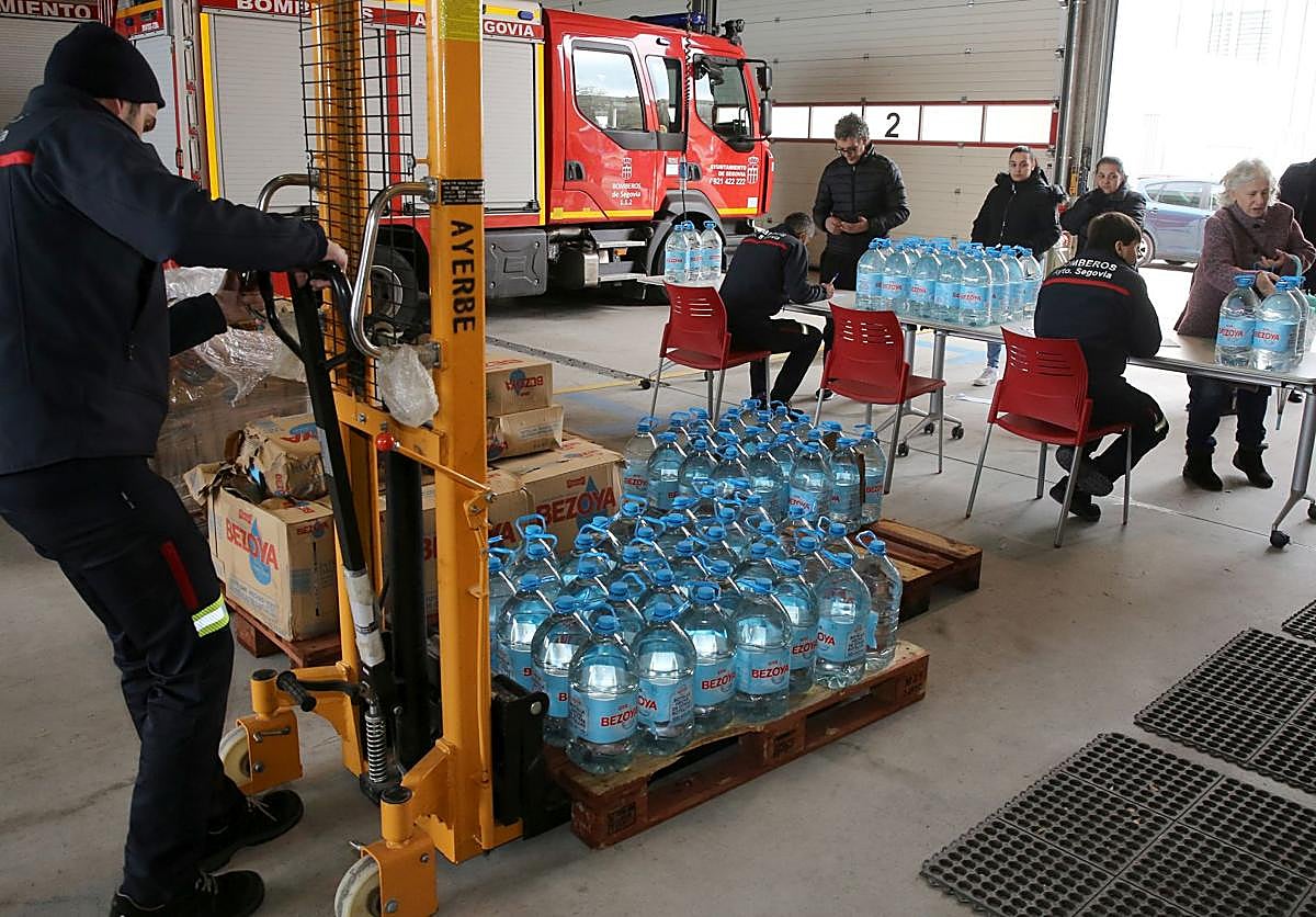 Los bomberos reparten agua durante un episodio de contaminación del agua.