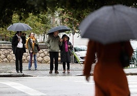 Viandantes con paraguas en Madre de Dios durante la tormenta del miércoles.