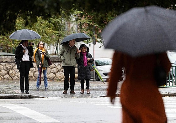 Viandantes con paraguas en Madre de Dios durante la tormenta del miércoles.