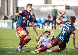 Fer Llorente y Josep Jaume tratan de recuperar el balón ante un jugador del Rayo Cantabria.