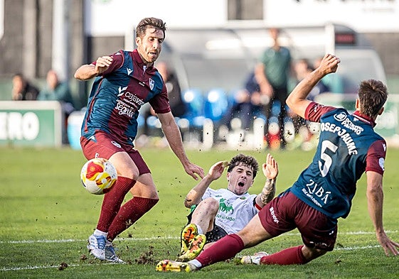 Fer Llorente y Josep Jaume tratan de recuperar el balón ante un jugador del Rayo Cantabria.