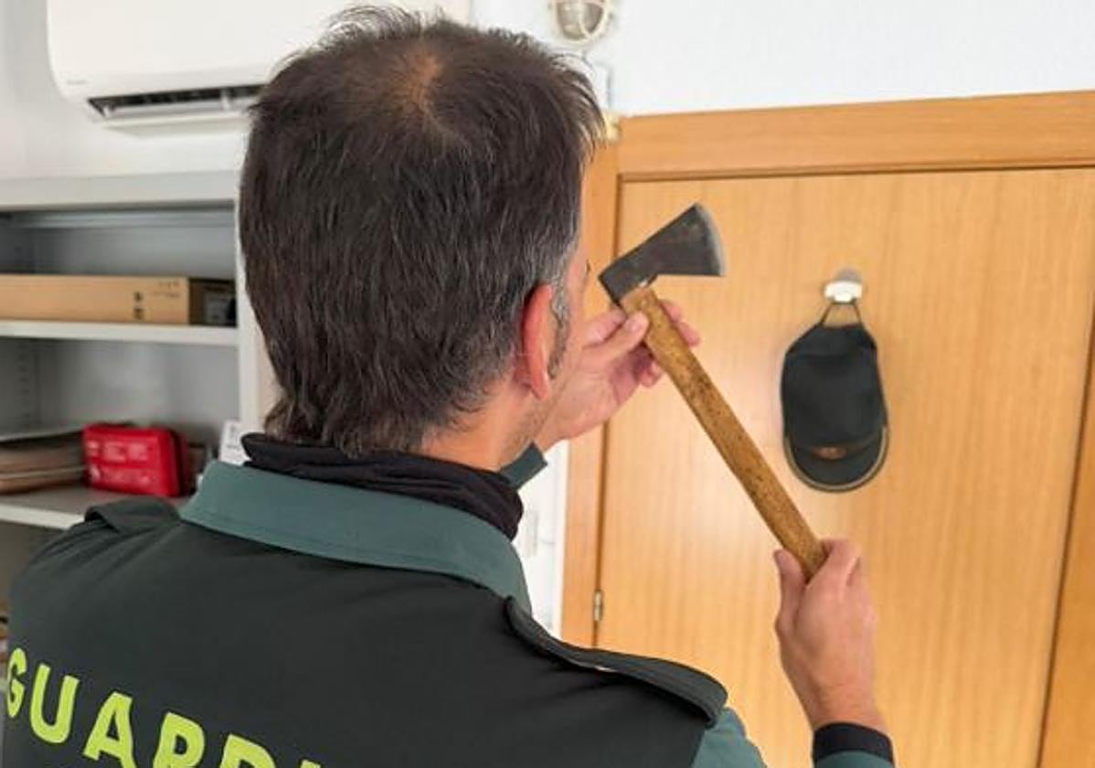 Un agente de la Guardia Civil, con el hacha intervenido.