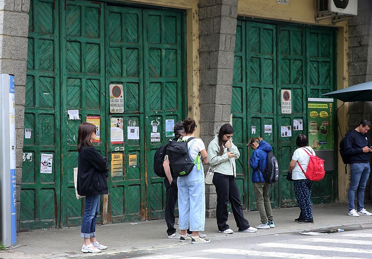 Un grupo de personas espera el autobús que une Segovia con Madrid en la parada frente al cuartel de la Guardia Civil.