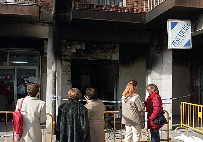Los vecinos observan la sede vecinal incendiado durante un robo el 4 de diciembre de 2001.