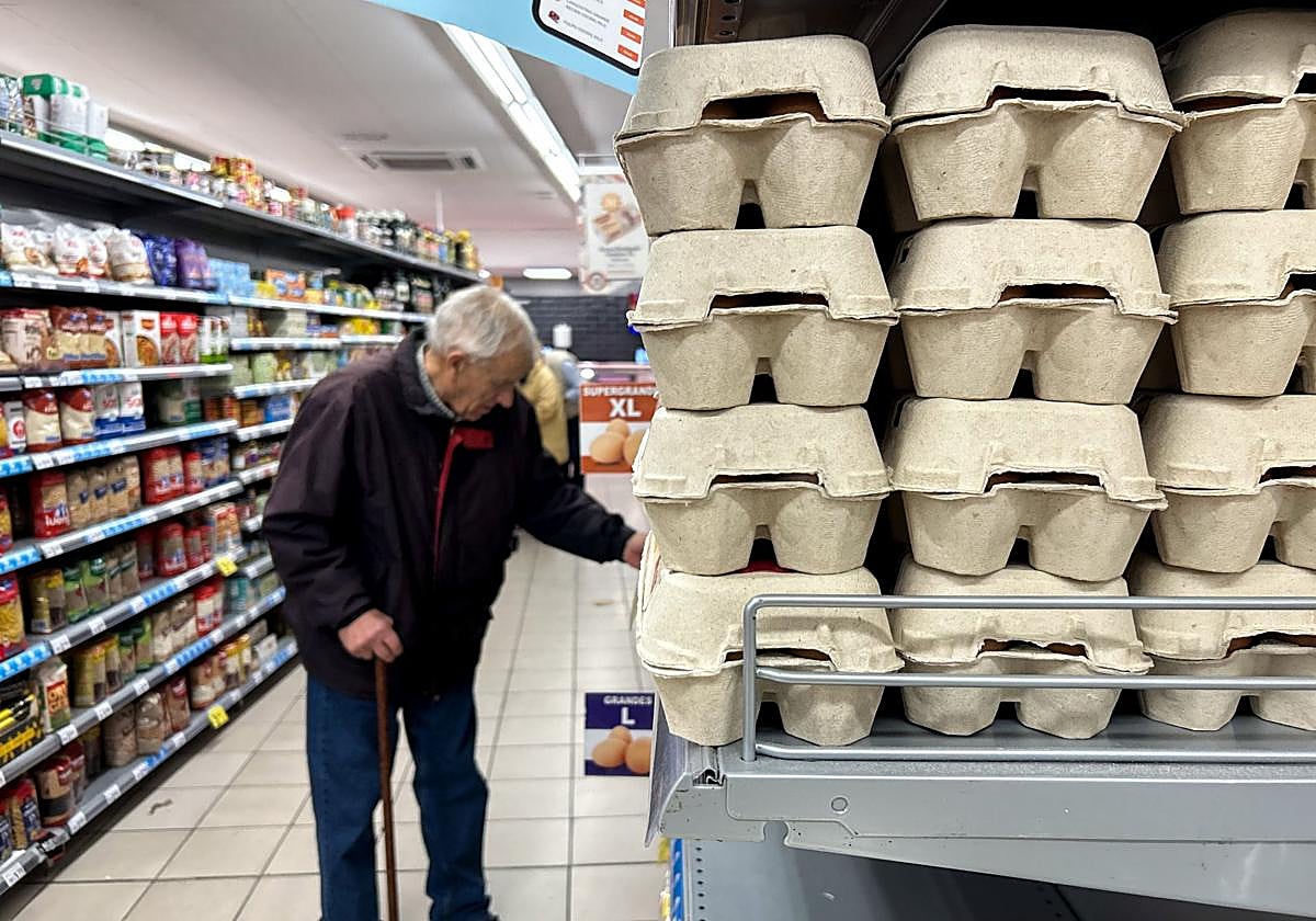 Un hombre mira el precio de los huevos en un supermercado.