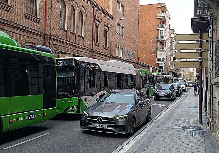 Hilera de coches y autobuses este viernes por la mañana en la calle López Gómez.