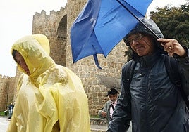 Viandantes se protegen de la lluvia en Ávila capital este jueves.