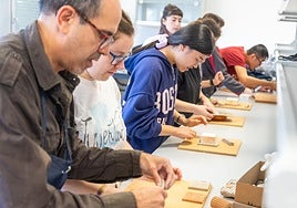 El profesor José Luis González, a la izquierda, guía a los alumnos el trabajo en barro.