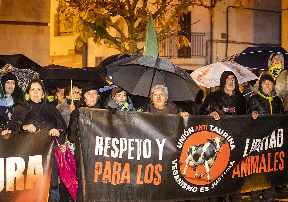 Imagen principal - Concentración en protesta que demandaba la suspensión del Toro Jubilo. El animal embarrado y con los cuernos embolados sobre los que se prende fuego y con las llamas ya prendidas.