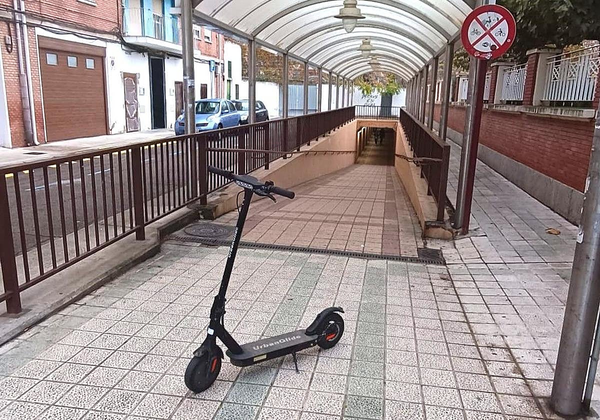 Un patinete aparcado delante de un subterráneo, por los que tienen prohibida la circulación