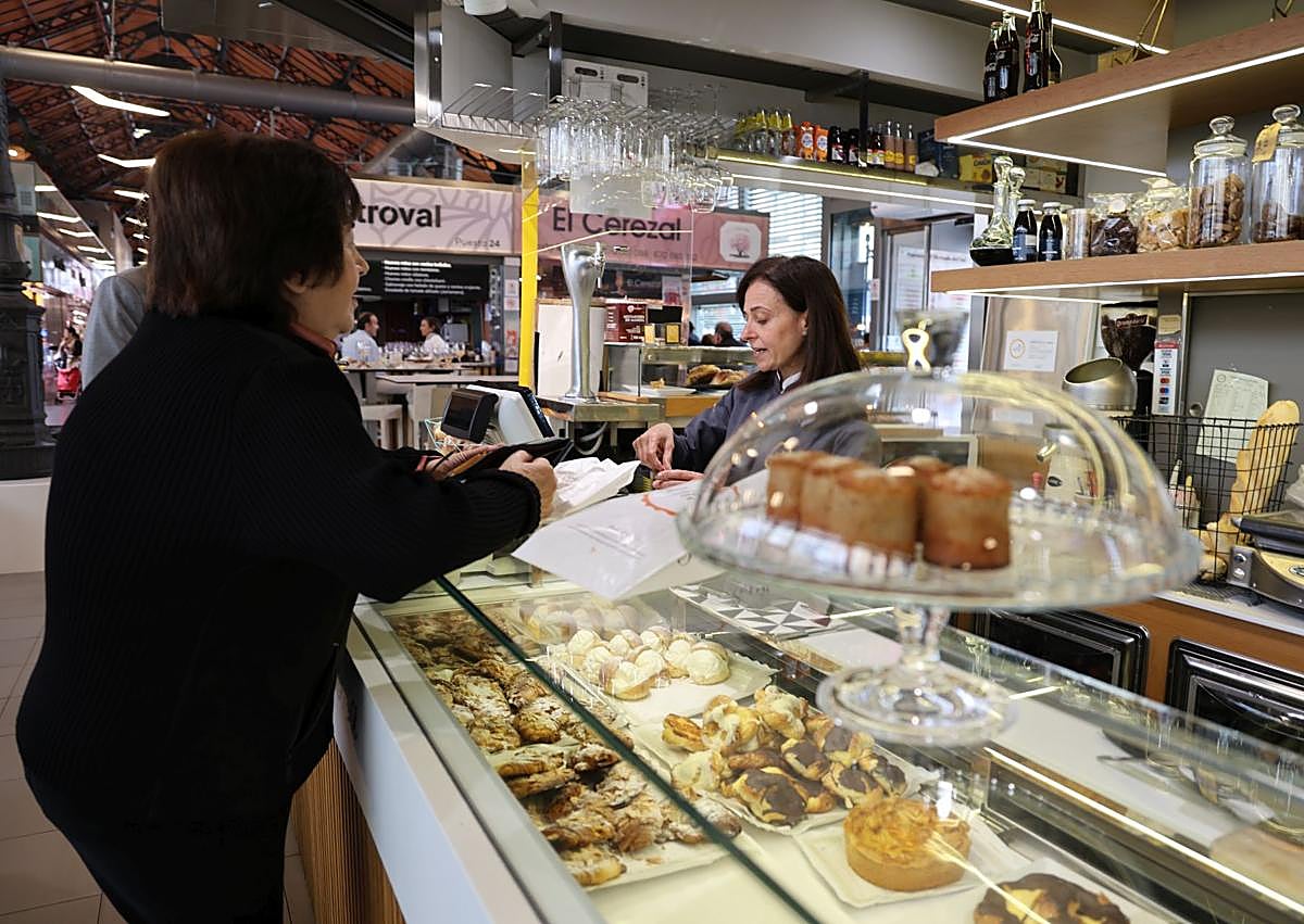 Imagen secundaria 1 - La escritora vallisoletana Esperanza Ortega en el quiosco de la Plaza de la Rinconada, la panadería El Fiel y el bar La Provinciana del Mercado del Val.