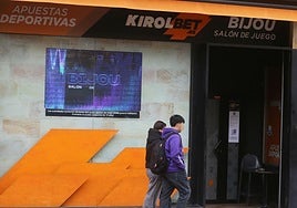 Dos personas caminan junto al acceso a un salón de juego.