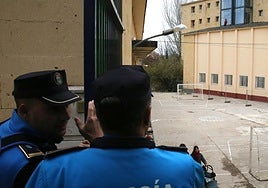 Agentes de la Policía Local de Segovia y al fondo los operarios en el tejado del edificio en obras al otro lado del patio de La Aneja.