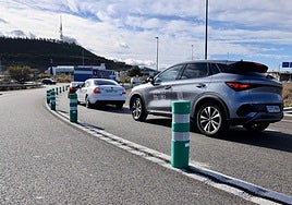 Varios vehículos circulan en el vial de acceso a la rotonda de La Cistérniga desde la VA-30, con los bolardos colocados para separar los dos carriles de circulación.