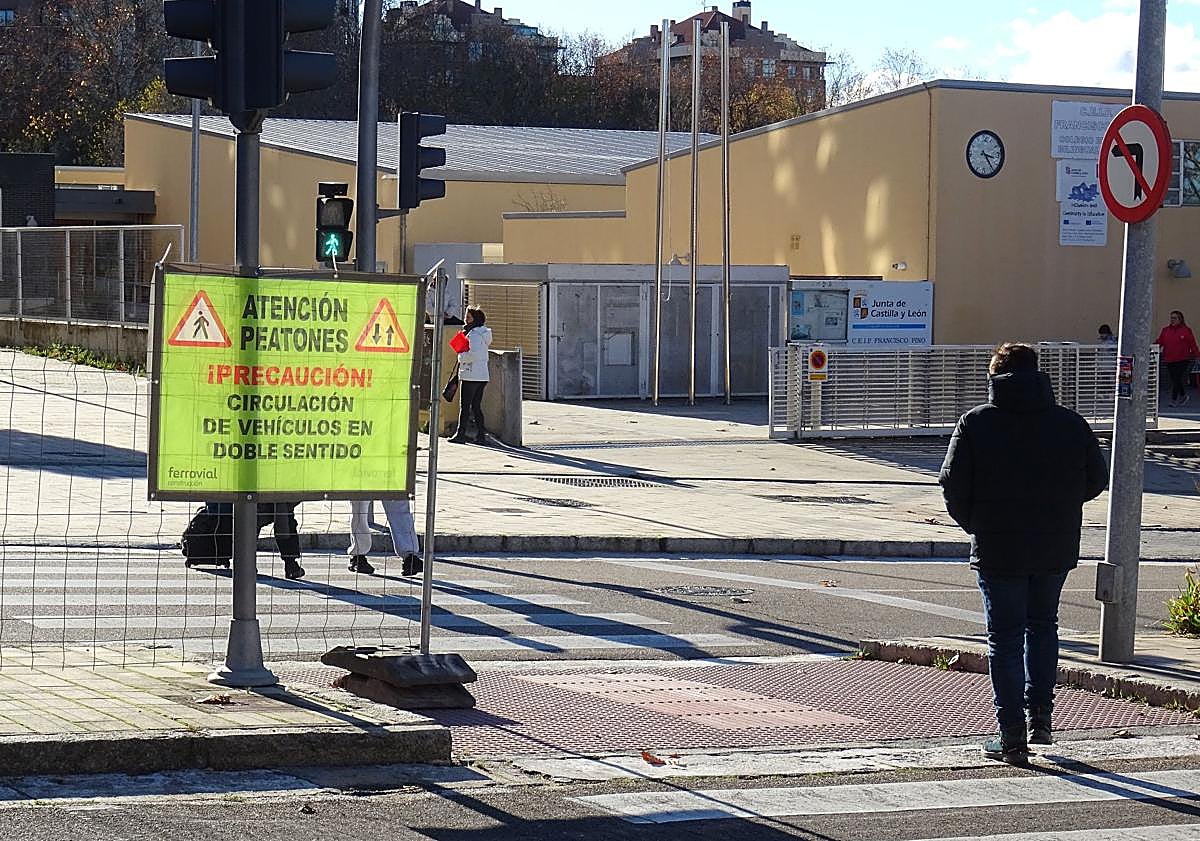 Imagen principal - Arriba, el cartel que advierte de que pasan vehículos en los dos sentidos ante el colegio Francisco Pino. Debajo, a la izquierda, un coche dando la vuelta para salir del tramo cortado de Hernando de Acuña. Debajo, los separadores que indican el corte en la parte alta de la calle.