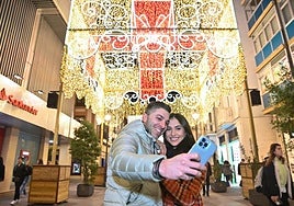 Una pareja se hace un selfie con la iluminación navideña de la calle Santiago en años anteriores.