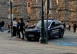 Patrulla de la Policía Nacional identifica a dos personas junto al Acueducto de Segovia.