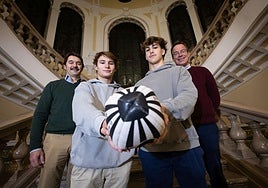 Santi Toca y Alvar Enciso, en segundo plano, posan sonrientes junto a sus hijos en la escalinata de la Universidad.