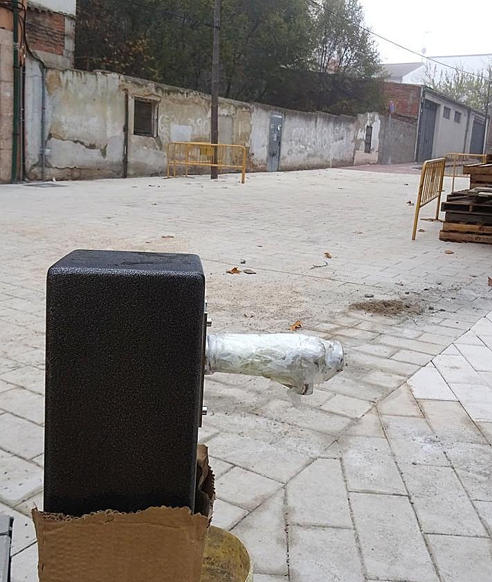 Imagen secundaria 2 - Arriba, el tramo peatonalizado del inicio de la calle Teófilo Villamañán. Debajo, a la izquierda, los alcorques elevados de los árboles. A la derecha, la nueva fuente instalada junto al parque infantil.