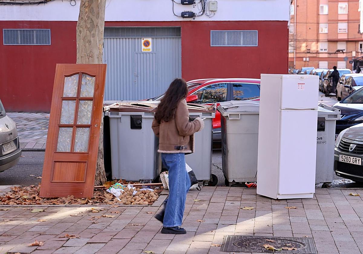 Una puerta y una nevera junto a unos contenedores en la calle Amor de Dios este miércoles.