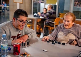 Luisa y Adrián jugando al dominó.