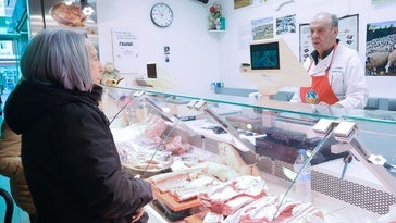 Clientas adquiriendo lechazo en el puesto de Juan Carlos Tordera en el Mercado del Val este miércoles.